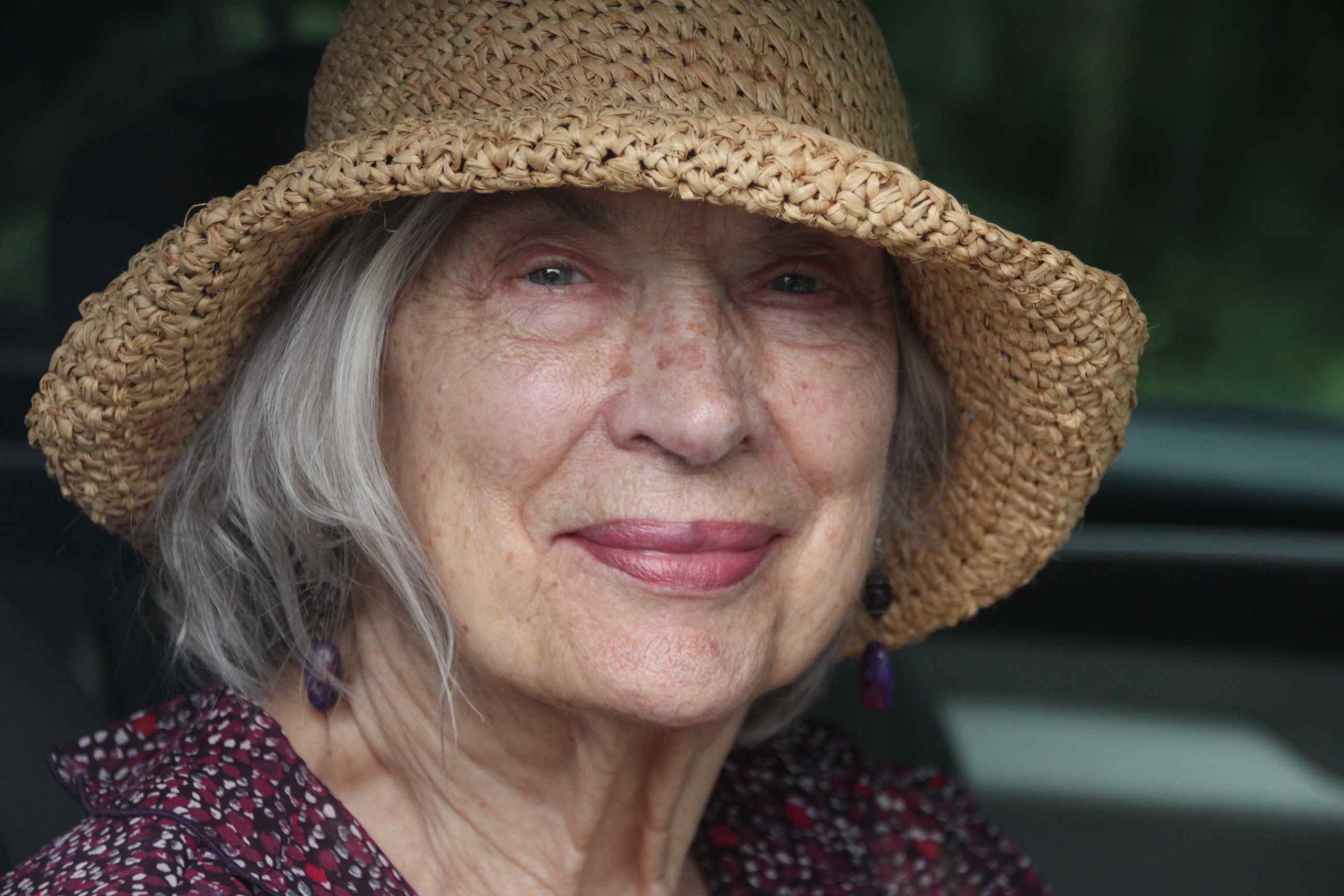 Aldona Page  in a straw hat smiling.
